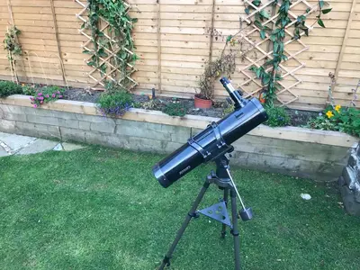 a telescope on a tripod in a yard at A Wee Cottage In Dunfermline in Dunfermline