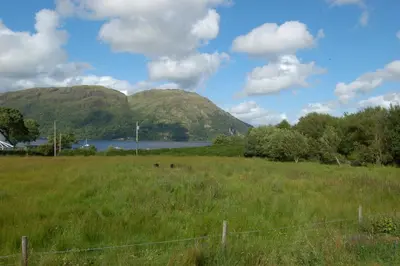 a field of grass with mountains in the background at Mountain View in Taynuilt