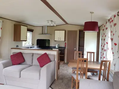 a living room and kitchen with a couch and a table at Glen View in Taynuilt