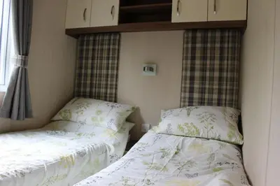 a bedroom with two beds and a window at Glen View in Taynuilt