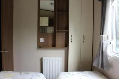 a bedroom with a bed and a cabinet and a window at Glen View in Taynuilt
