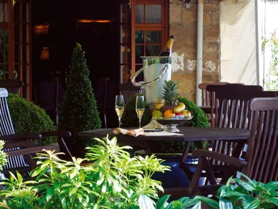 a table with wine glasses and fruit on a patio at Champany Inn in Linlithgow