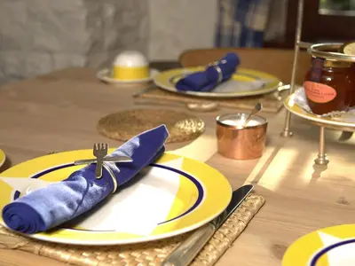 a table with yellow and blue plates and utensils at Champany Inn in Linlithgow