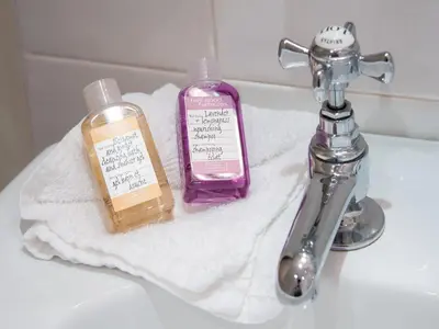 a bathroom sink with two bottles of soap on a towel at Champany Inn in Linlithgow