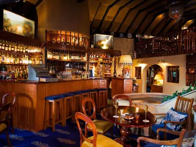a bar with tables and chairs in a room at Champany Inn in Linlithgow