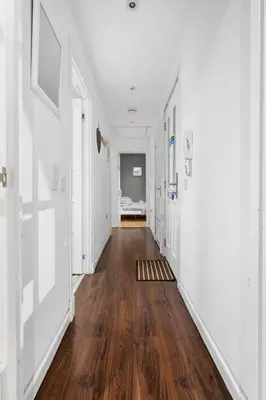 an empty hallway with wooden floors and white walls at Beautiful 2BR Apartment with McCaigs Tower views in Oban