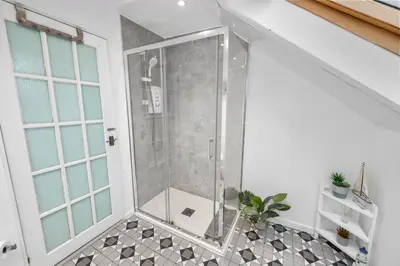 a shower with a glass door in a bathroom at Beautiful 2BR Apartment with McCaigs Tower views in Oban