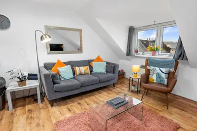 a living room with a couch and a table at Beautiful 2BR Apartment with McCaigs Tower views in Oban