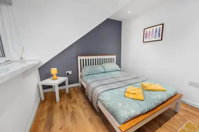 a bedroom with a bed with a blue accent wall at Beautiful 2BR Apartment with McCaigs Tower views in Oban