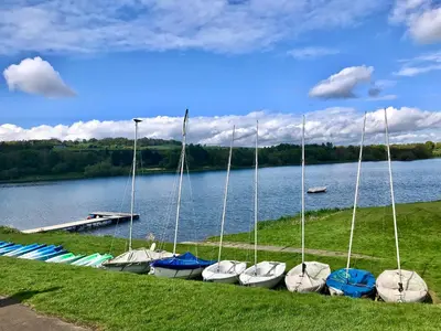 a row of boats parked on the shore of a lake at Central Apartment Linlithgow in Linlithgow