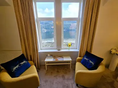 a living room with two chairs and a large window at Lochwood Guest House in Lochgoilhead