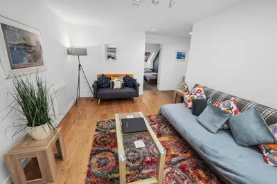 a living room with a couch and a table at Stunning 2BR Loft Apt in Oban - Sea Views in Oban