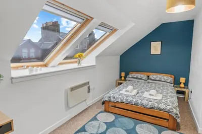 a bedroom with a bed and a window at Stunning 2BR Loft Apt in Oban - Sea Views in Oban