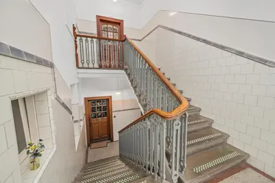 a staircase in a house with a wooden door at Panoramic Sea Views - Stunning 3BD Apt & Balcony in Oban