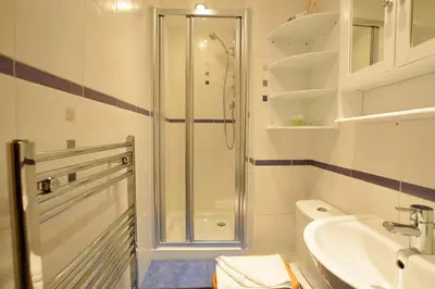 a bathroom with a shower and a toilet and a sink at JOIVY Classic Apt with Castle Views in Old Town in Edinburgh