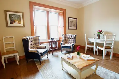 a living room with chairs and a table at JOIVY Classic Apt with Castle Views in Old Town in Edinburgh