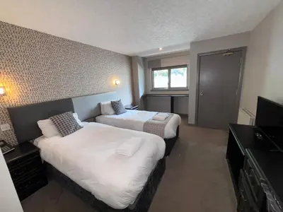 a hotel room with two beds and a television at Richmond Park Hotel in Boʼness