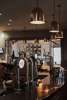 a kitchen with a bar with a counter top with at Richmond Park Hotel in Boʼness