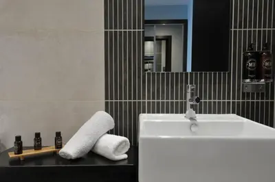 a bathroom with a white sink and a mirror at The Lodge On Loch Lomond Hotel in Luss
