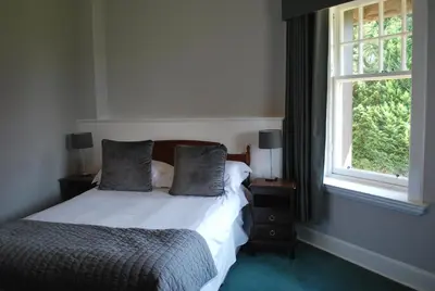 a bedroom with a bed with two pillows and a window at Dunmar House Hotel - Bar & Restaurant in Alloa