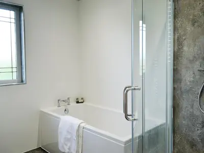 a bathroom with a bath tub and a shower at Hillview in Beith