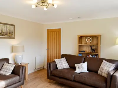 a living room with two brown leather couches at Hillview in Beith