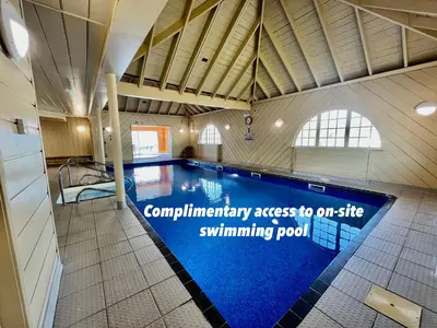 a swimming pool in a building with a sign that reads compliance access to our site at Beach Houses with Hot Tubs in Glencoe
