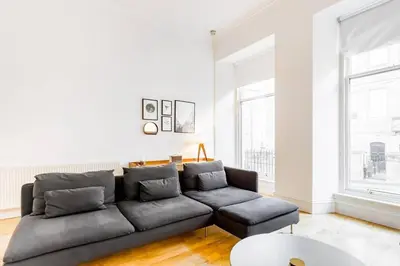 a living room with a couch and a table at Incredible contemporary flat in heart of west end in Glasgow