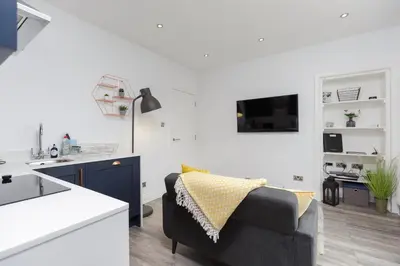 a kitchen and living room with a couch and a table at Dollar Apartments-39 Bridge Street in Dollar