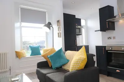 a living room with a couch and a window at Dollar Apartments-39 Bridge Street in Dollar
