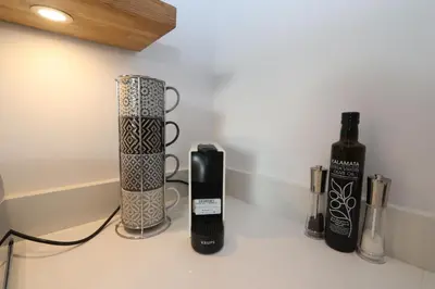 a counter with two vases and two bottles on it at Dollar Apartments-41 Bridge Street in Dollar