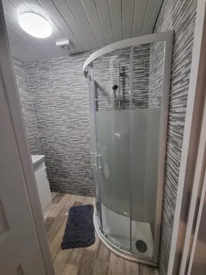 a shower with a glass door in a bathroom at Windsor house in Stranraer