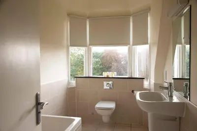 a bathroom with a toilet and a sink and a window at The Murray Park Hotel in Crieff