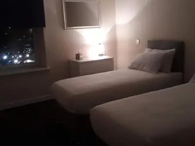 a hotel room with two beds and a window at Stonefield Rooms in High Blantyre