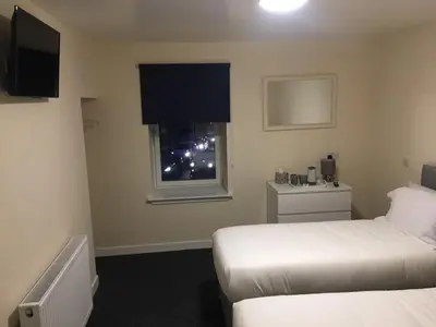 a hotel room with a bed and a window at Stonefield Rooms in High Blantyre