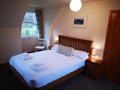 a bedroom with a bed with towels on it at Achalic Beag in Lerags