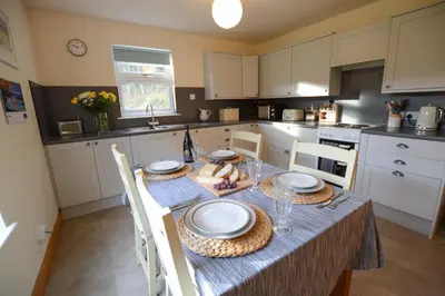 a kitchen with a table with plates and glasses on it at Achalic Beag in Lerags