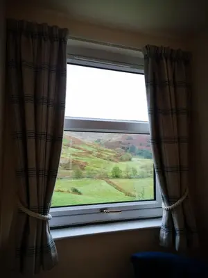 a window with a view of a green field at Achalic Beag in Lerags