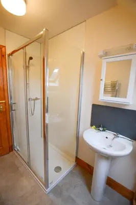 a bathroom with a shower and a white sink at Achalic Beag in Lerags