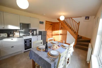a kitchen and dining room with a table and chairs at Achalic Beag in Lerags