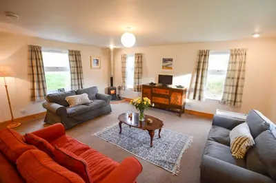 a living room with couches and a coffee table at Achalic Beag in Lerags