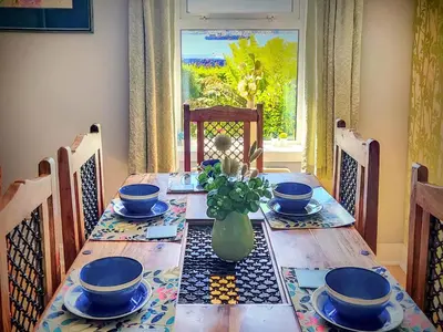 a table with blue dishes and a vase on it at Firwood Apartment in Kilmun