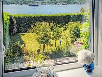 a window with a view of the water at Firwood Apartment in Kilmun