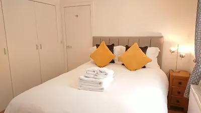 a bedroom with a bed with towels and pillows at Violet Bank Apartment West End. in Edinburgh