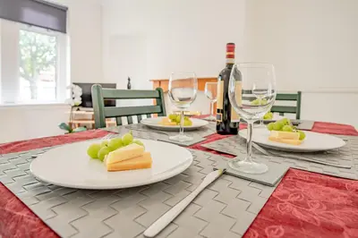 a table with plates of cheese and wine glasses at Stirling Mercury Apartment - Scotland Holiday Let in Stirling