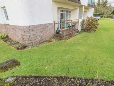 a yard in front of a house with a fence at Cumbrae View in Largs