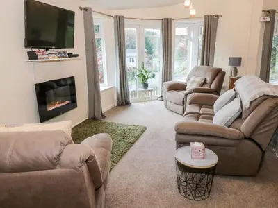 a living room with two couches and a fireplace at The Wee Lodge in Glendevon