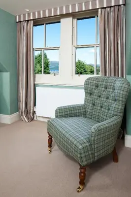 a living room with a chair and a window at The Loch Lomond Arms Hotel in Luss