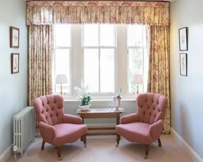 a living room with two chairs and a table and a window at The Loch Lomond Arms Hotel in Luss