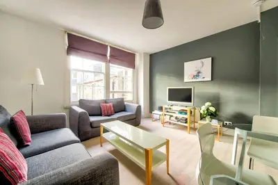 a living room with a couch and a tv at JOIVY Bright 1 bed flat, close to Princess Street in Edinburgh